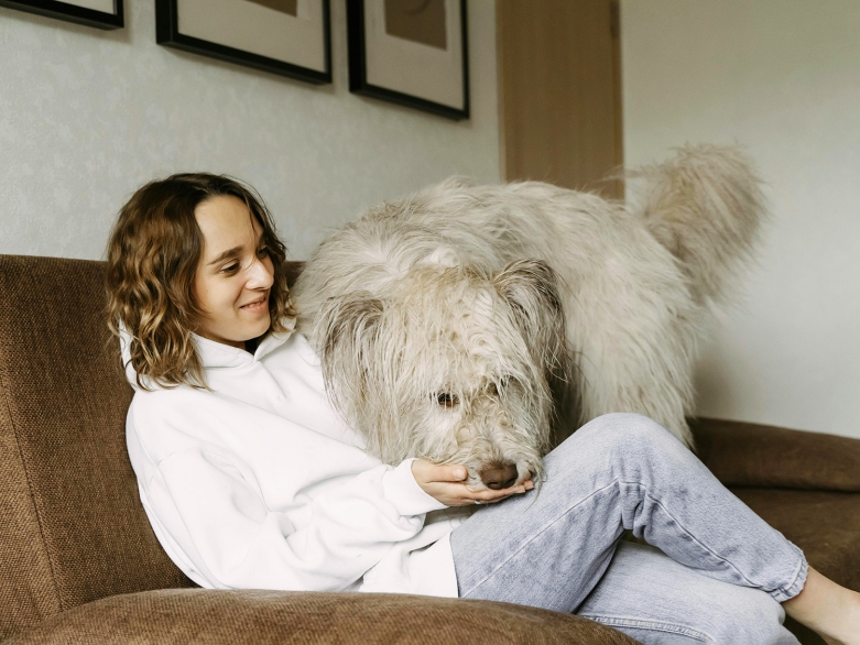 Frau mit Hund auf dem Sofa