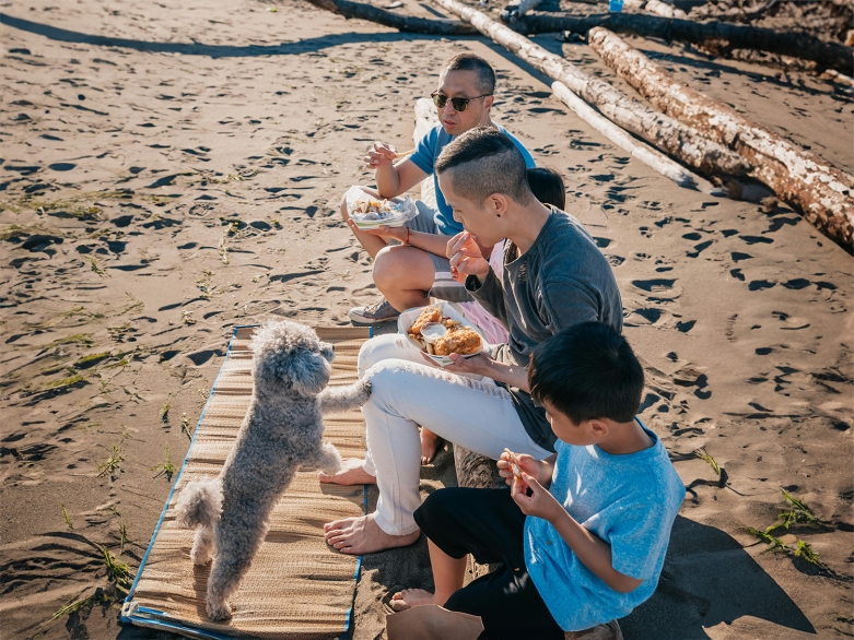 Familie mit Pudel am Strand